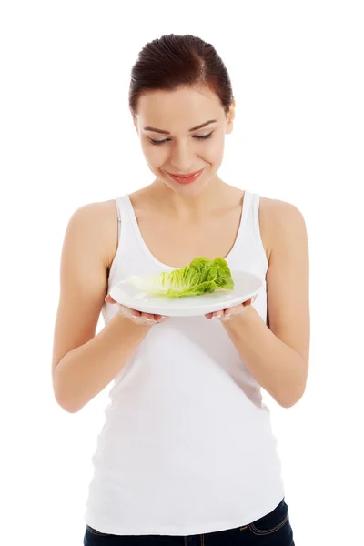 Young beautiful woman holding leaf of lettuce on plate — Stock Photo, Image