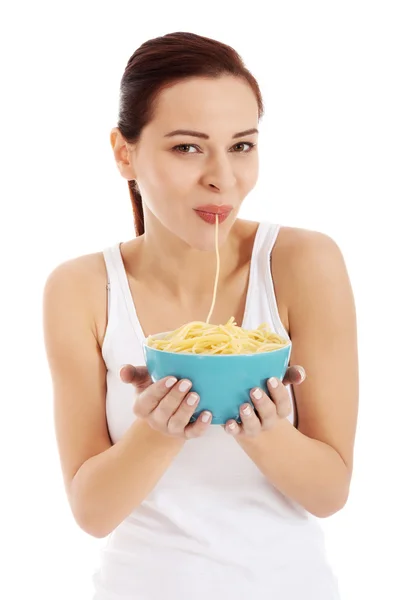 Schöne Frau isst Pasta aus einer Schüssel. — Stockfoto