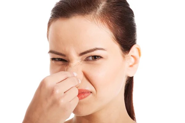 Portrait of a young woman holding her nose. — Stock Photo, Image