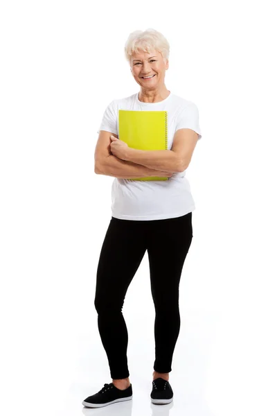 An old woman holding a workbook. — Stock Photo, Image