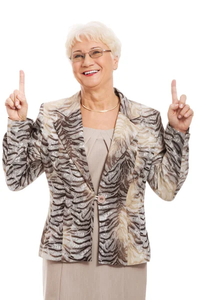 An old casual lady pointing up on copy space. — Stock Photo, Image