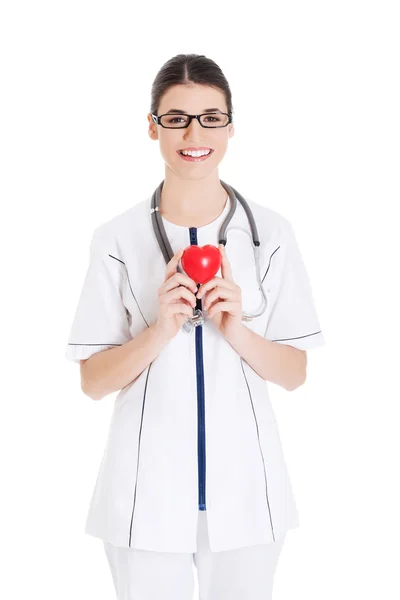 Bonito jovem médico segurando um coração . — Fotografia de Stock