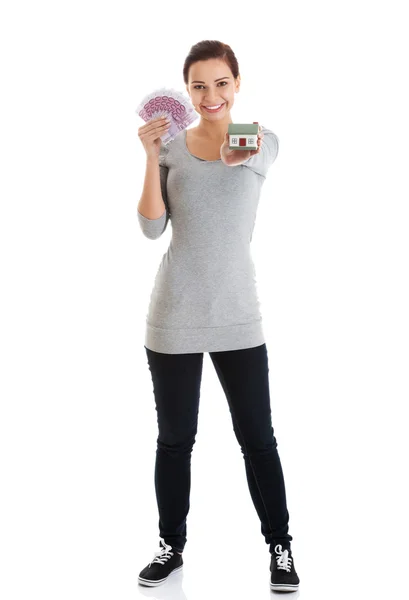 Beautiful young, casual woman holding money and house. — Stock Photo, Image