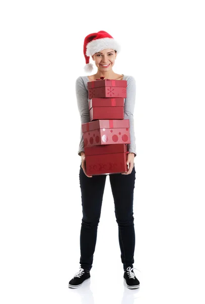 Beautifull woman in santa hat holding presents. — Stock Photo, Image