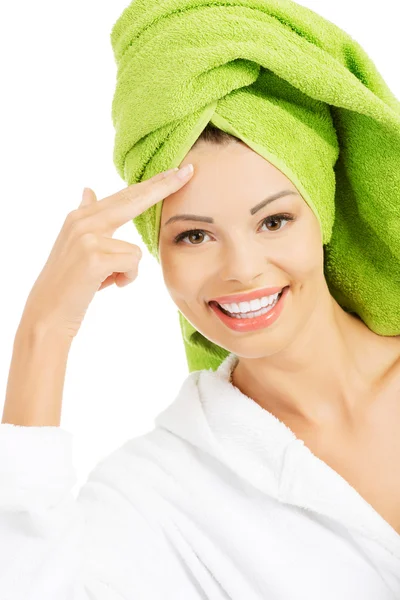 Beautiful woman in bathrobe and turban is touching her forehead. — Stock Photo, Image