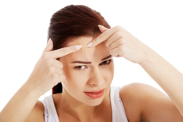 Young woman is pimpling spot on forehead. Stock Picture