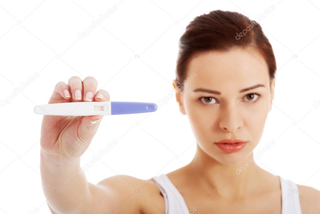 Sad, worried woman with pregnancy test.