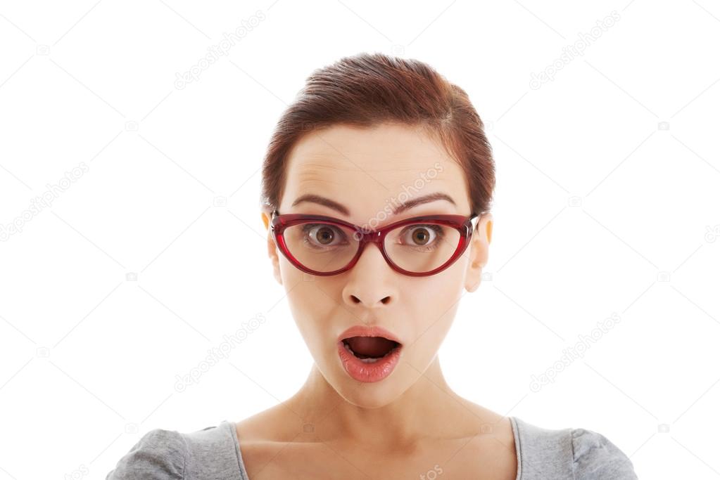 Young casual woman in eyeglasses expresses shock.