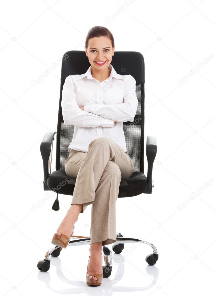 Beautiful happy business woman sitting on a chair.