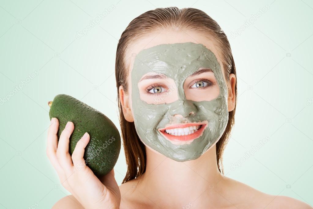 Beautiful woman with green avocado clay mask