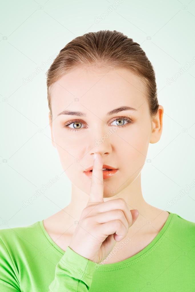 Teen girl with finger on her lips.