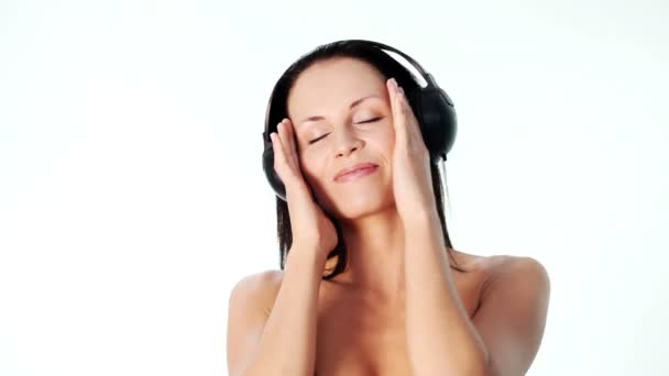 Sensuelle femme seins nus dansant avec des écouteurs sur la tête 