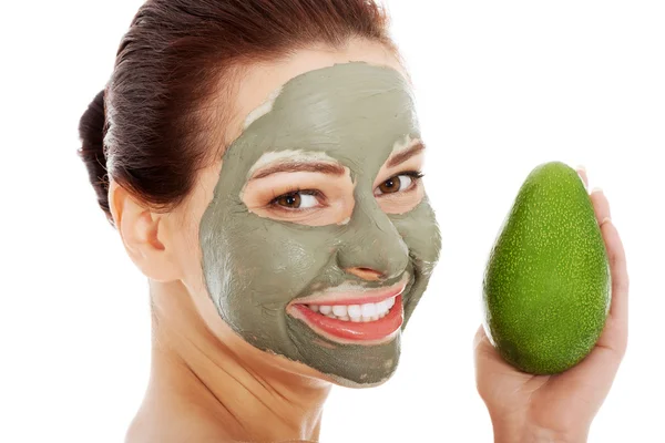 Schöne Wellness-Frau in Gesichtsmaske und Avocado. — Stockfoto