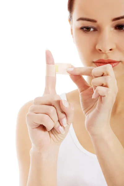 Beautiful fit woman with plaster on finger. — Stock Photo, Image