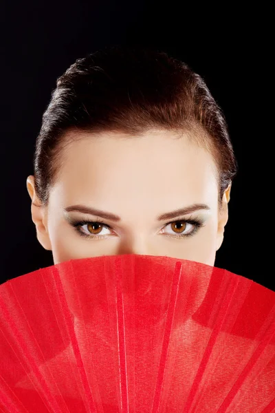 Hermosa mujer en rojo sexy vestido con ventilador . — Foto de Stock