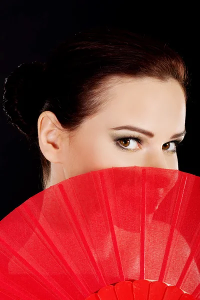 Bella donna in abito sexy rosso con ventilatore . — Foto Stock