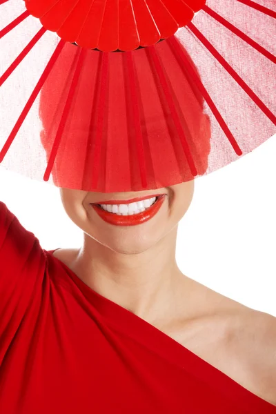 Beautifull kvinna i sexig röd klänning med fläkt. — Stockfoto
