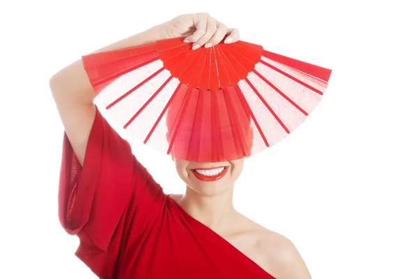 Frumos femeie în roșu rochie sexy cu ventilator . — Fotografie, imagine de stoc