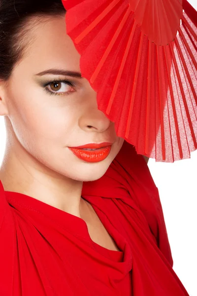 Vacker kvinna i röd sexig klänning med fläkt. — Stockfoto