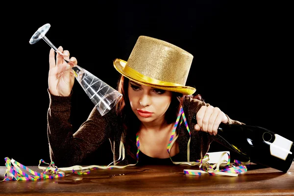 Jovem bêbada sentada perto de uma mesa . — Fotografia de Stock