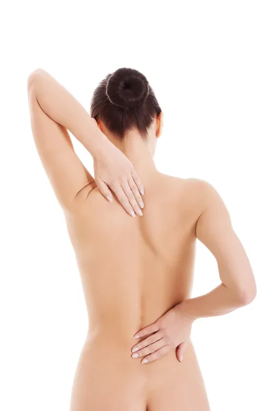 Beautiful naked woman touching her back. Stock Picture