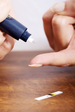 şeker seviyesi testi yapıyor kadın.