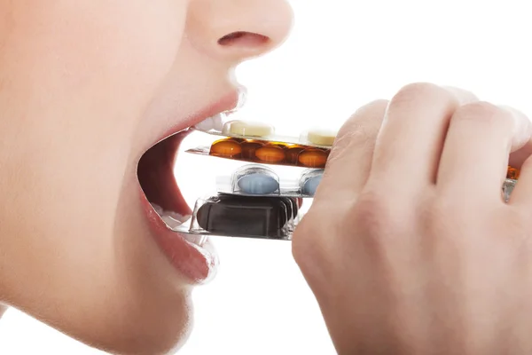 Young woman eating pills. — Stock Photo, Image