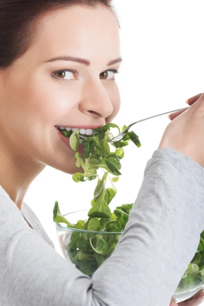 Young casual woman eating lamb's lettuce. — Stock Photo, Image