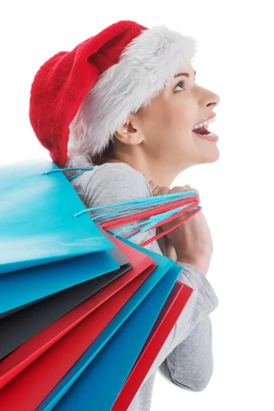 Hermosa mujer en Santa sombrero con bolsas de compras . — Foto de Stock