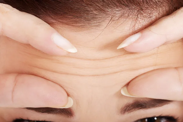 Jonge vrouw controleren haar rimpels op het voorhoofd. — Stockfoto