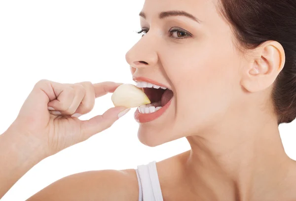 Vacker kvinna äta vitlök. — Stockfoto