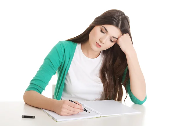 Young casual woman writing in workbook. — Stock Photo, Image