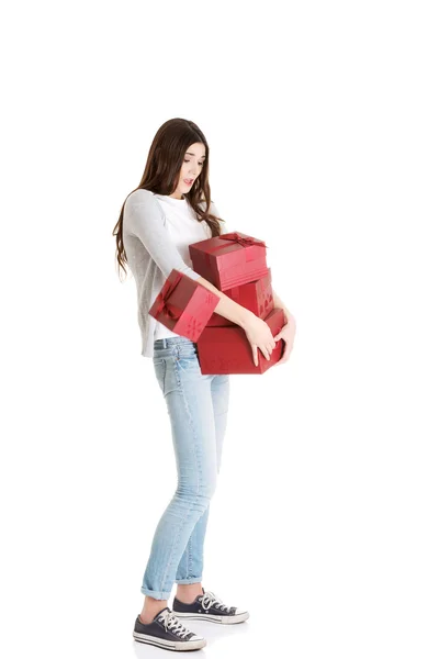 Young casual woman holding stock of presents. — Stock Photo, Image