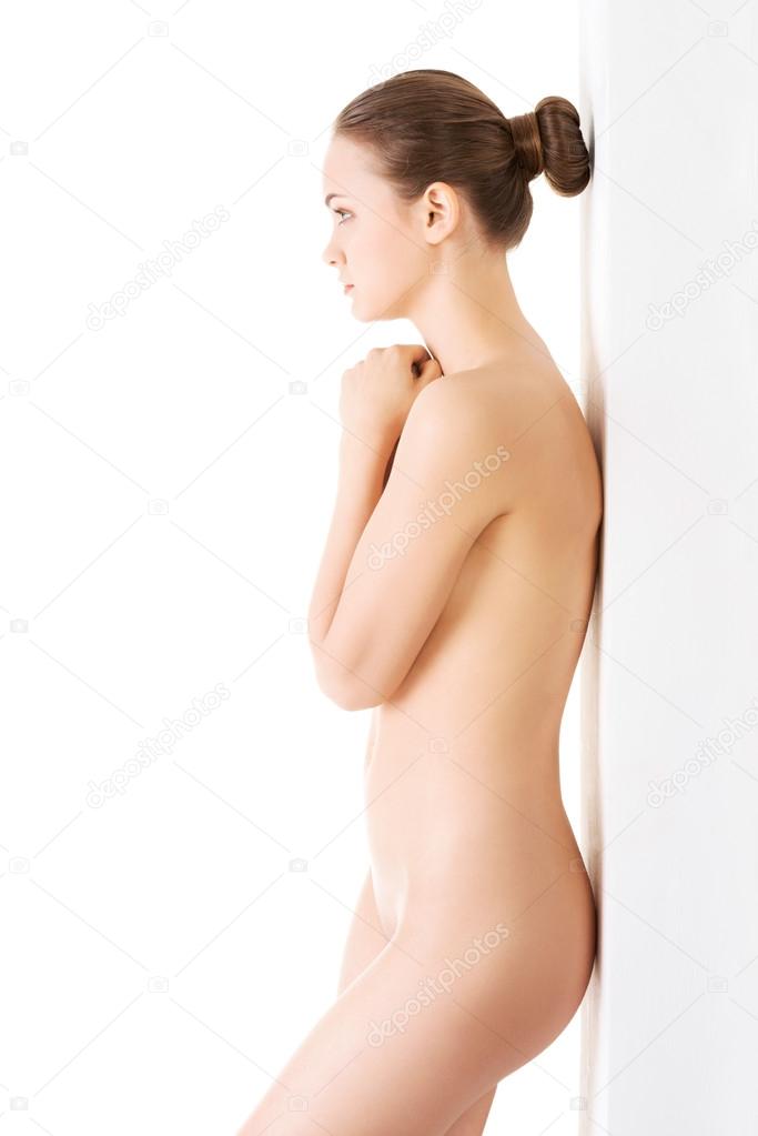 Attractive naked young woman standing with her hand together.