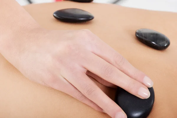 Närbild på honans rygg med stone massage. — Stockfoto