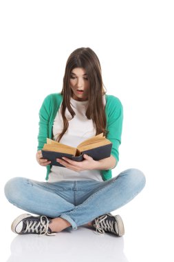 genç kadın öğrenci oturan ve bir kitap okuma.