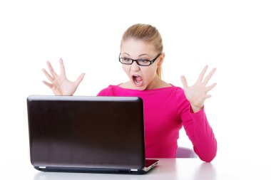 laptop önünde oturan genç şaşırmış kadın.