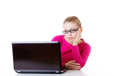 laptop önünde oturan sıkılmış, hüzünlü kadın.