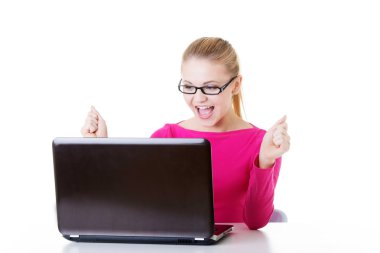laptop önünde oturan genç mutlu kadın.