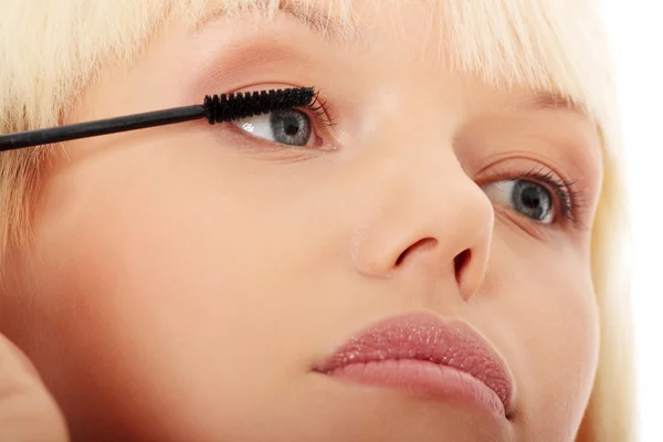 Close-up em bela jovem fazendo maquiagem em pestanas . — Fotografia de Stock