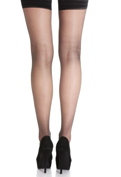 Kvinnans ben i svarta strumpor och höga klackar. — Stockfoto