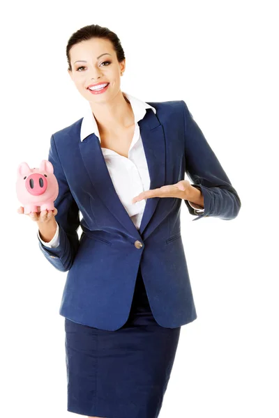 Jovem empresária segurando porquinho banco . — Fotografia de Stock