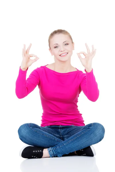 Young casual woman student showin OK gesture. — Stock Photo, Image