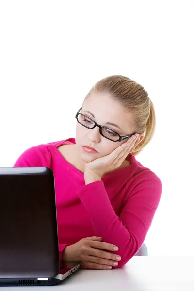 Mujer aburrida y triste sentada frente al portátil . — Foto de Stock