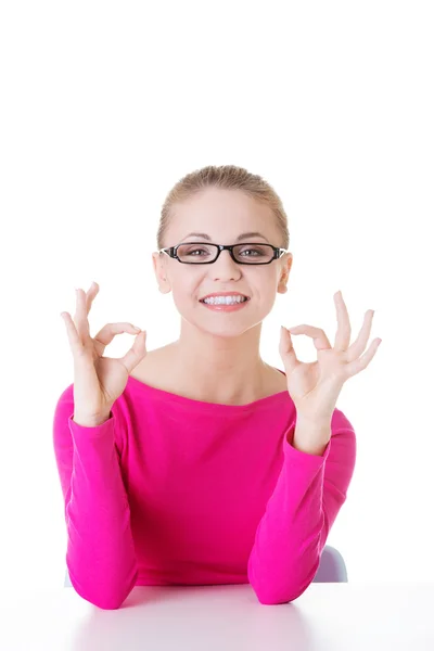 Young casual woman student showin OK gesture. — Stock Photo, Image