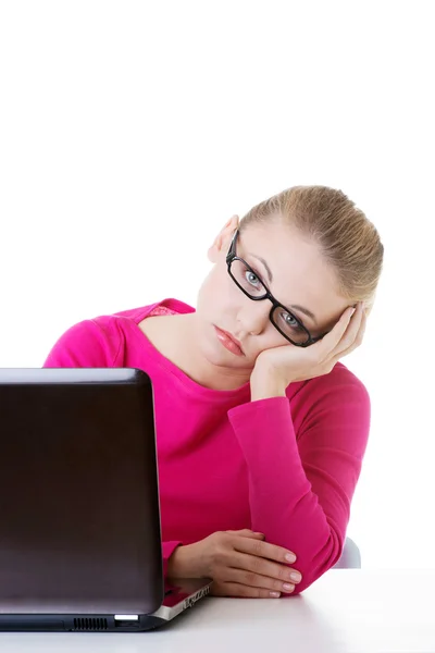 Mujer aburrida y triste sentada frente al portátil . — Foto de Stock