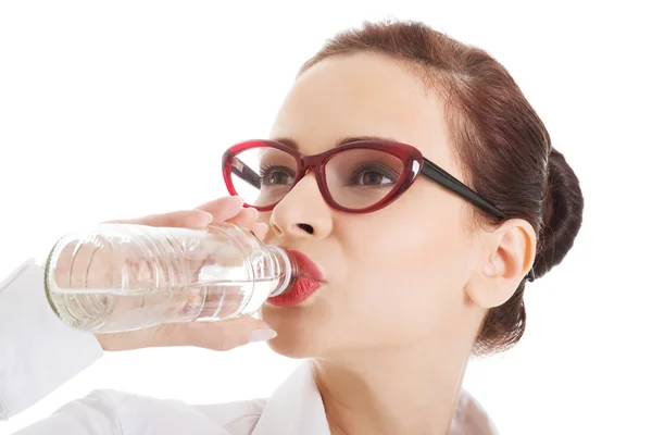 Mooie zakenvrouw met plastic fles water. — Stockfoto