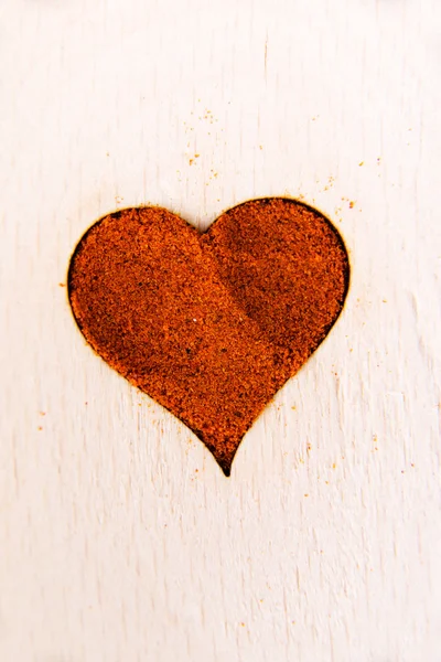 Forma de corazón hecha de especias en una cuchara de madera . — Foto de Stock
