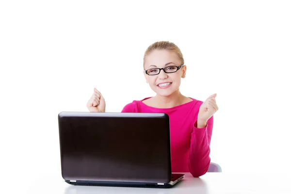 Молодая счастливая женщина сидит перед ноутбуком . Лицензионные Стоковые Изображения