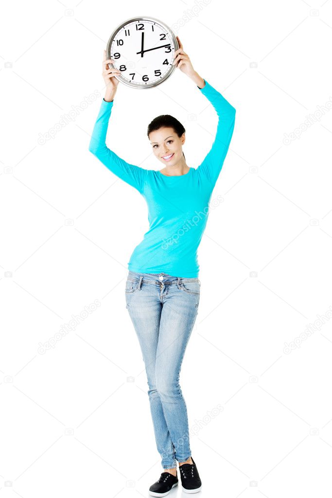 Young casual woman holding clock.